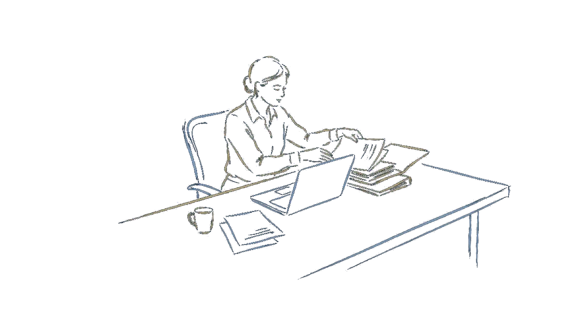 Une personne range ses dossiers autour d'un ordinateur portable ouvert sur son bureau