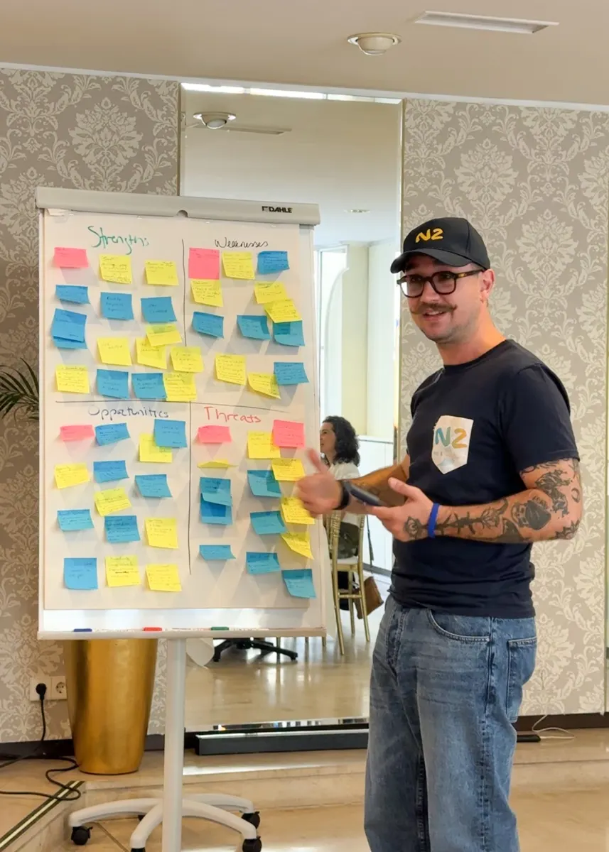Jessy Martin leading a workshop in front of a wall of sticky notes at the N2 Fall Gathering