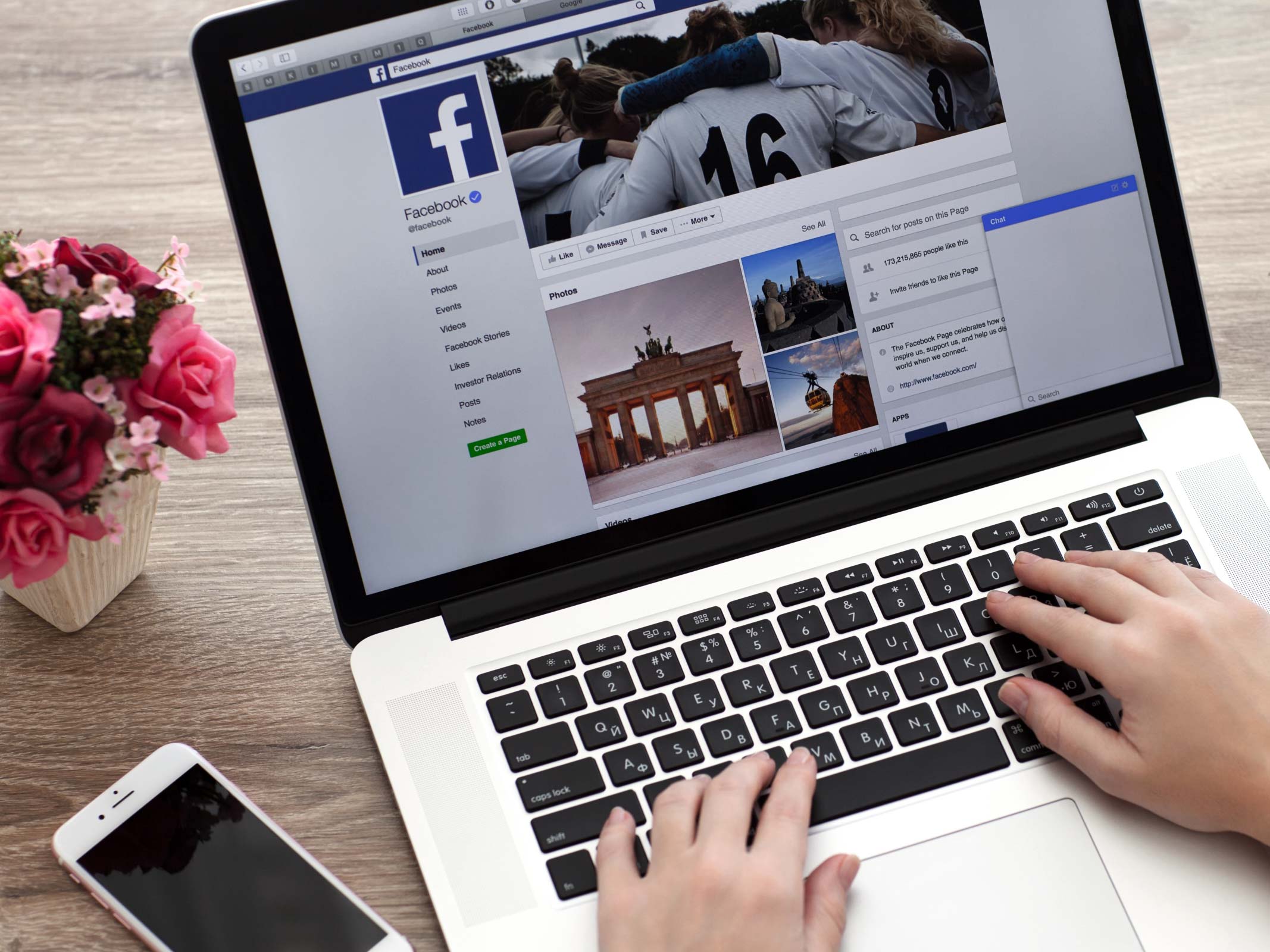facebook ouvert sur un ordinateur portable avec deux mains tapant sur le clavier